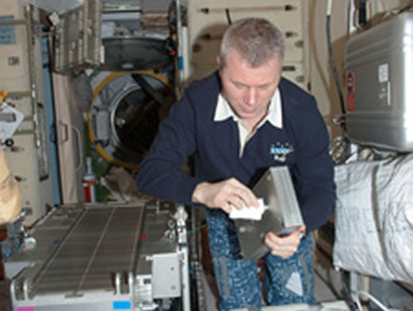 Flight Engineer Oleg Novitskiy performs routine in-flight maintenance on the Tre