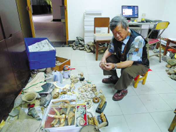 十几平方米的工作室地上摆放着古生物化石、瓷器、陶器等文物。