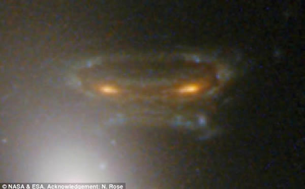 前景星系簇“艾贝尔68”在引力场作用下扭曲空间并使背景遥远星系失真的虚幻图像,这种效果叫做“引力透镜”,能够多重镜像复制遥远星系的光线