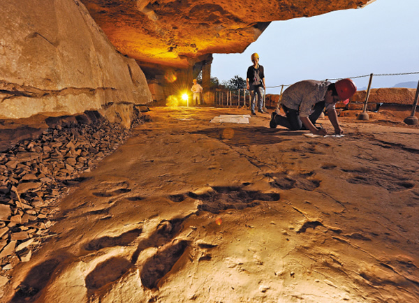 绝壁上的莲花保寨,天然的横向凹洞,为完美保存鸭嘴龙类恐龙留下的足迹创造了绝佳的条件。科研人员正在测量和记录这些远古的记忆