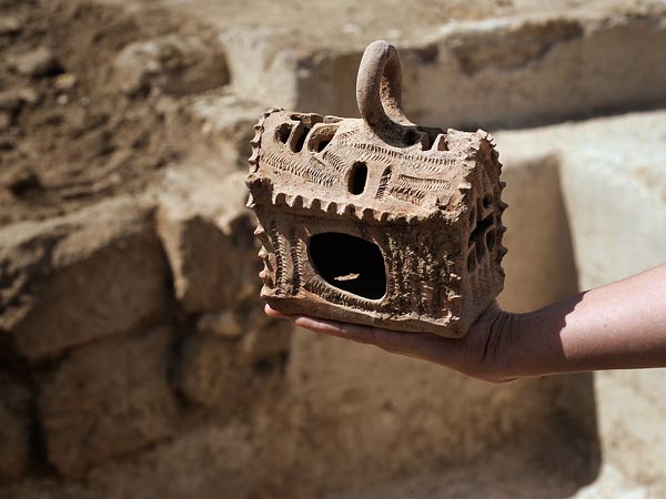 A church-shaped lantern found near a Byzantine wine press casts flickering cross