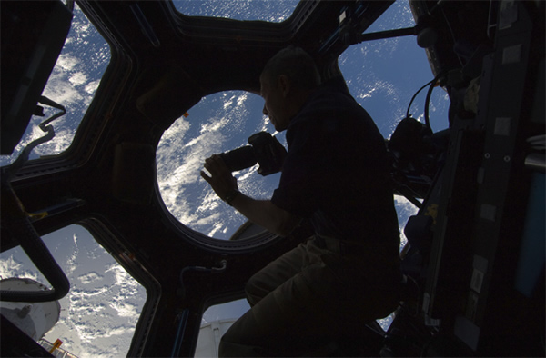 NASA astronaut Mike Fossum, Expedition 29 commander, uses a still camera to phot