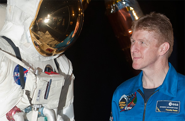 British astronaut Major Tim Peake poses for photographs next to a spacesuit at t