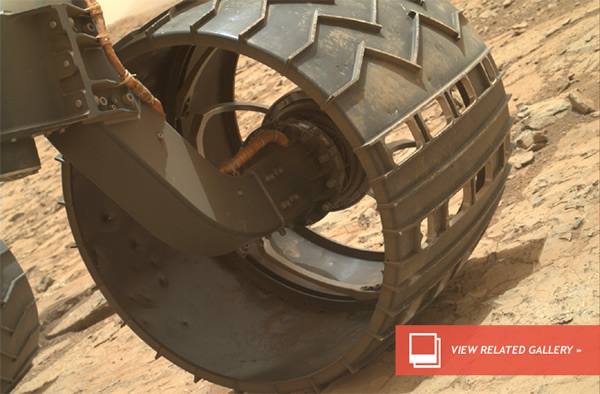 Curiosity’s dusty wheels. Dents are evident on the inner edge of the wheel’s ski