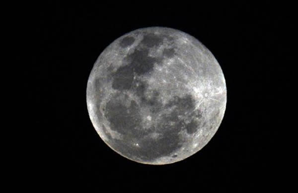 2013年4月25日晚拍摄的巴拿马城上空的皓月当空。一项最新研究显示,月球上一部分陨坑内部的物质可能是撞击月球的小天体的残留物,而非长期以来人们认为的那样是由于