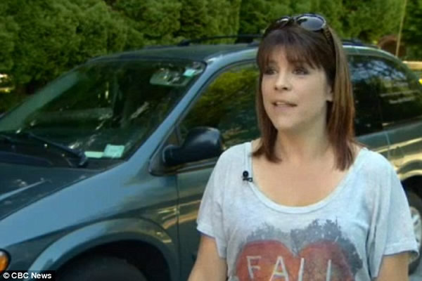 加拿大一只黑熊欲爬上汽车