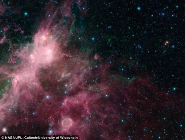 一颗发生超新星爆炸的恒星残余向外喷射海草状细丝结构。粉红色巨浪云内正在形成大质量恒星。大质量恒星团照亮这些云,图像底部附近的一个“气泡”由大质量恒星形成