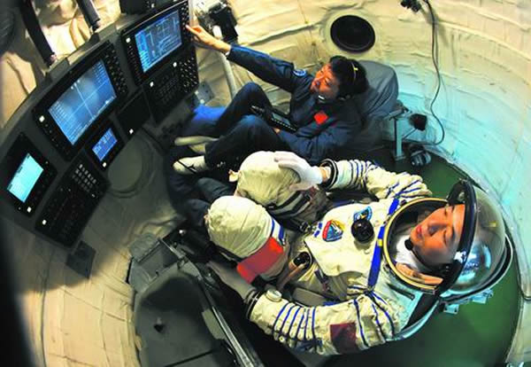 航天员在模拟返回舱内进行手控交会对接训练