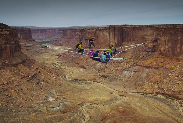 美国探险队在峡谷上空拉绳索体验高空露营