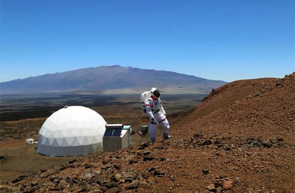A HI-SEAS crew member walks in a spacesuit during the 2013 HI-SEAS simulated spa