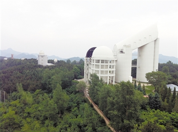 郭守敬望远镜(大天区面积多目标光纤光谱天文望远镜,简称LAMOST)的穹顶打开,中国科学院国家天文台兴隆观测站工作人员正在对其进行维护。