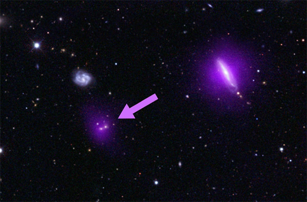 This optical color image of galaxies is seen overlaidwith X-ray data (magenta) f