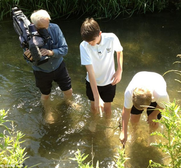 克里斯丁·汤姆森和罗比·克伯雷向当地一家电视台展示他们在何处发现头骨