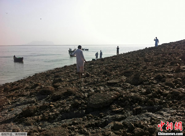 当地时间9月25日,巴基斯坦民众登上因地震冒出的小岛参观。