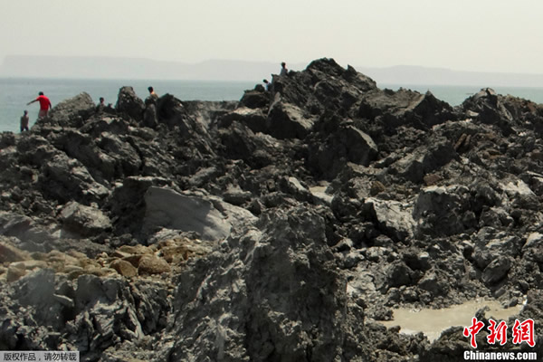 当地时间9月25日,巴基斯坦民众登上因地震冒出的小岛参观。