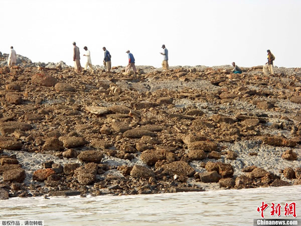 当地时间9月25日,巴基斯坦民众登上因地震冒出的小岛参观。