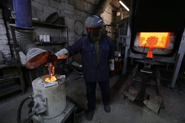 南安普敦的Polycast Limited公司,一名工匠正在熔化钢铁,随后铸造真正的飞车女神车头立标。