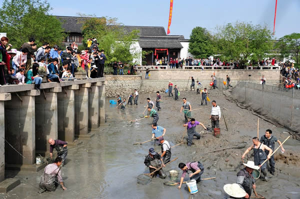 村民们将鱼塘内的水抽掉,抓鱼清淤,游客们可以租件下水服下到水塘里去“蹭塘儿”,抓到的小鱼小虾直接拎回家。