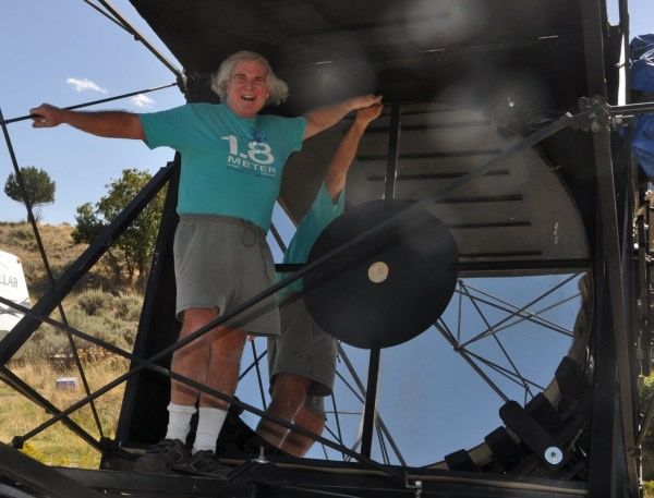 Telescope builder Mike Clements poses in front of the massive 70 inch wide mirro