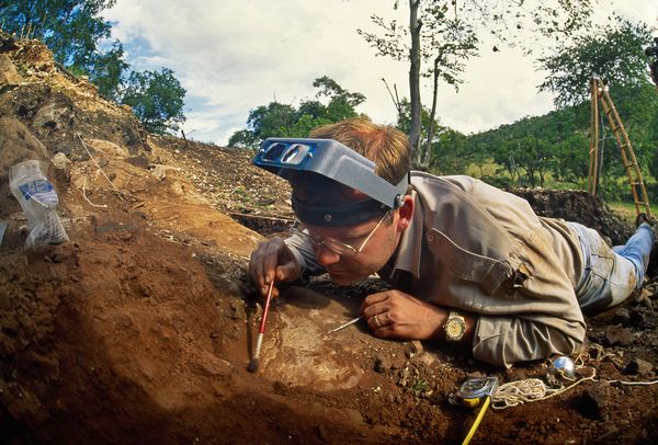 Dr. Lee Berger excavates a finger bone in South Africa in 1995.
