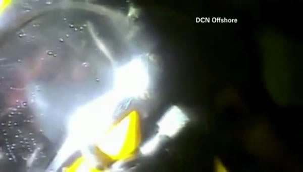 潜水员为幸存者哈里森·奥肯尼戴上氧气面罩