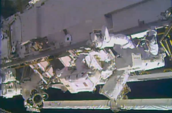 An astronaut spacewalks outside the International Space Station on Saturday, Dec