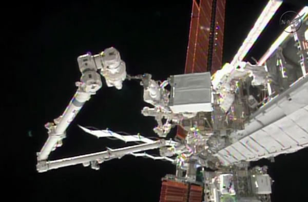 Astronaut Rick Mastracchio holds the degraded pump module while the Internationa