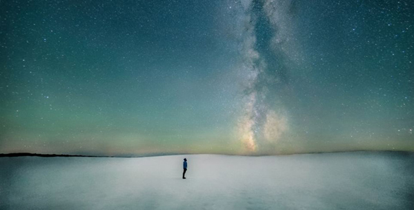 在这张照片中,远处的地平面上的银河像是升起一缕青烟,尘埃形成了一条暗巷,像银道坐标系般。