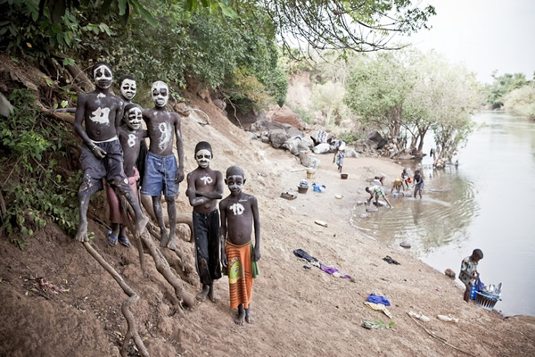 塞内加尔境内冈比亚河沿岸的男孩。他们用白色颜料把脸涂成骷髅模样,胸前写着足球队服上的号码做装饰。