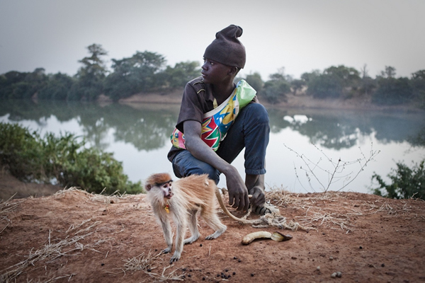 男孩穆萨·加罗(Musa Jallow)和他的宠物小赤猴。小赤猴的母亲已经被猎人杀死了。