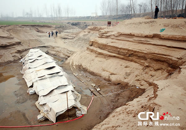 2014年1月6日,河南洛阳古沉船发掘现场,近日有雨雪天,考古人员给古沉船披上一层“雨衣”。