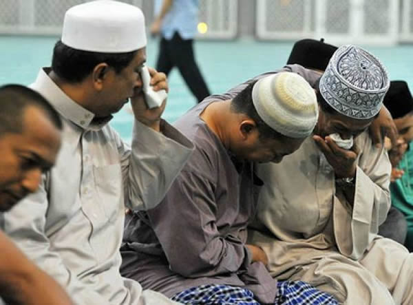 一批马来西亚航空公司回教徒职员在吉隆坡国际机场祈祷完后,想起失踪飞机与同事仍未寻获,不禁悲从中来相拥哭泣。