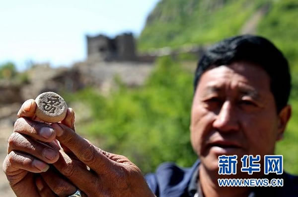 5月5日,河北省秦皇岛市抚宁县驻操营镇板厂峪景区,工作人员展示在明长城敌楼废墟里发现的象棋子。