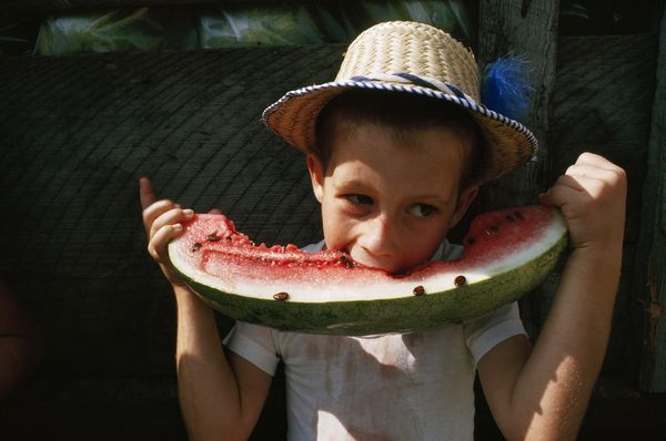 水果 摄影 西瓜/这个小男孩在一场庆典上大啖多汁的西瓜，整张脸都快埋进了西瓜...