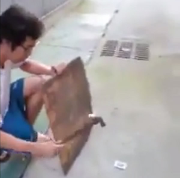 一名男子用铁锤猛力敲打手机电池,随后电池爆炸升空,变成火球坠落。