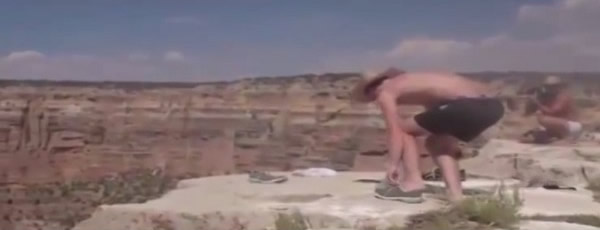 2名游客将面包屑撒在断崖边,准备引诱松鼠上钩。