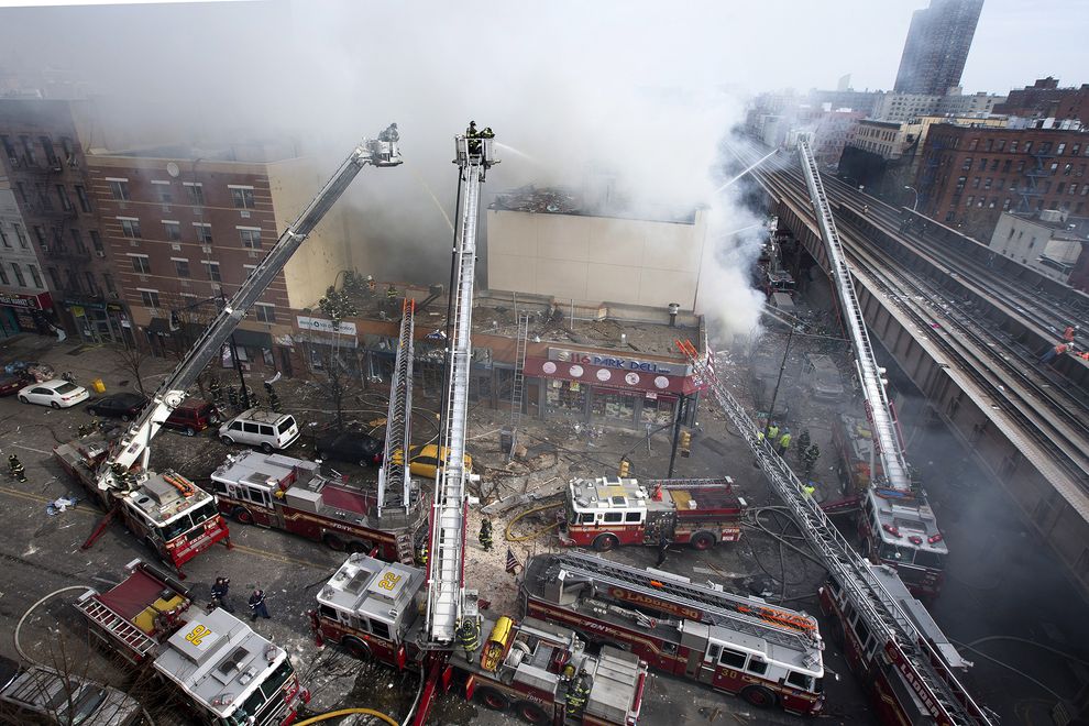 美国纽约市东哈林区气爆引发火灾与大楼倒塌后,浓烟仍从残垣断瓦中冒出。 PHOTOGRAPH BY JOHN MINCHILLO, AP