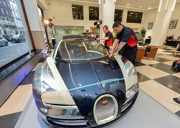 技术员在检查前,先用胶布封住车头灯和引擎盖边缘。