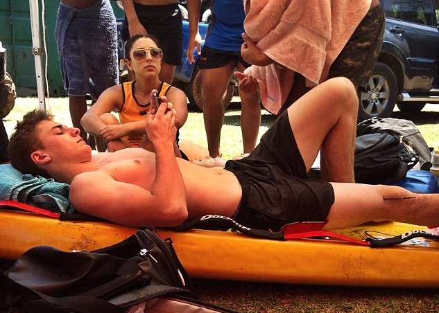 贾米森(中)等待救护人员期间仍不忘玩手机。