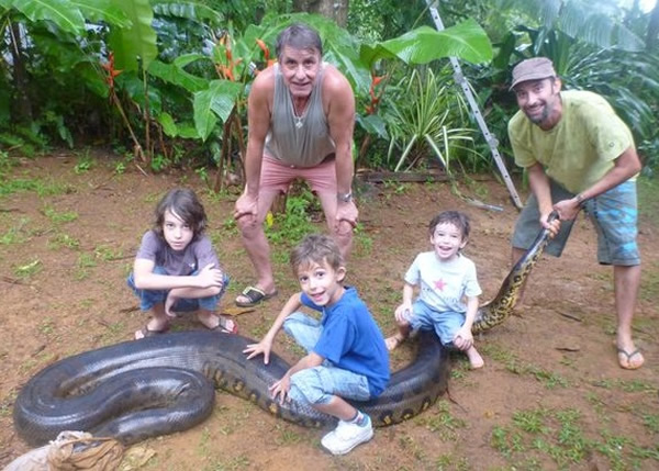 巴斯科内斯(右一)徒手捉起巨蟒,还让儿子坐在它身上。