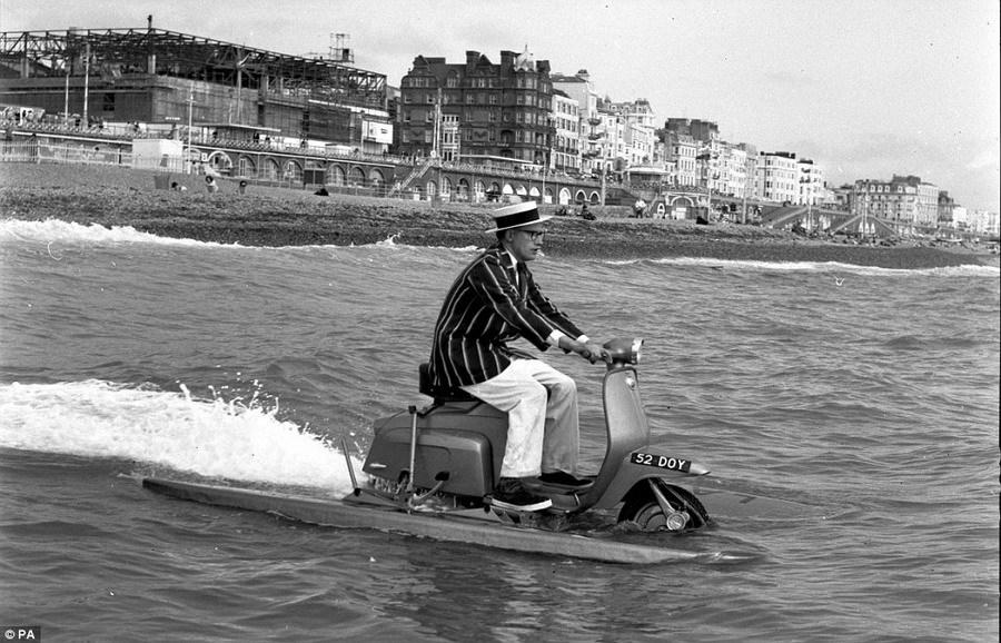 水陆两用车,一位年轻男子在海面上“乘风破浪”,实际上这个水陆两用车是由小轮摩托车和一块浮板构成的。