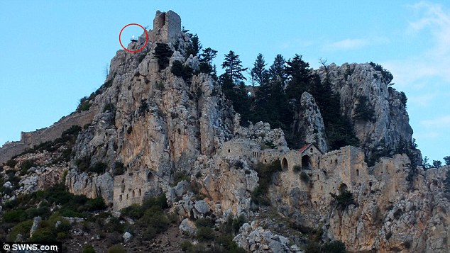 ���صİ�ɫ����վ��һ��������ͷ���Ϸ���ʥϣ�����̳Ǳ���Saint Hilarion Castle���Ĳt��̨�ϡ�