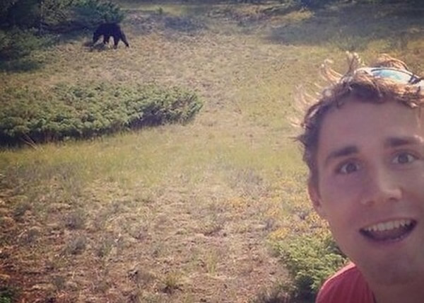 美国当局呼吁人们避免与熊接触。图为一名男子与熊自拍。