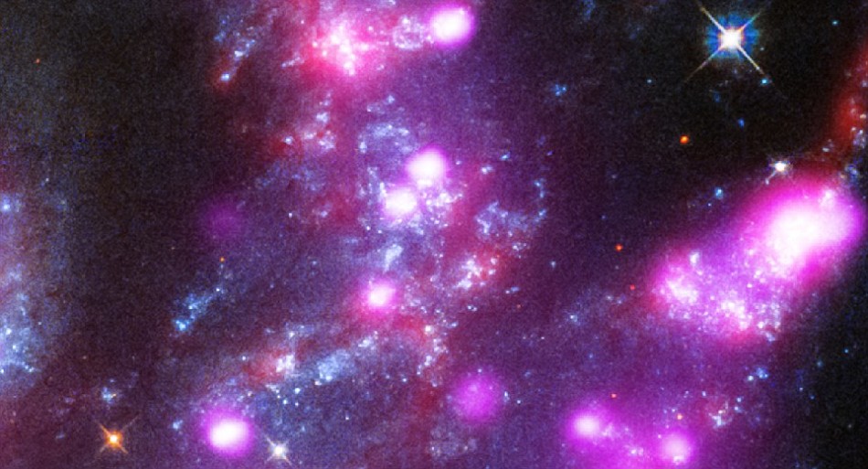 图像中的粉色代表来自“极高光度X射线源”(ULXs)的X射线波段辐射,科学家们认为这是一种特殊的双星系统;图像中同样也显示出活跃的恒星新生区域