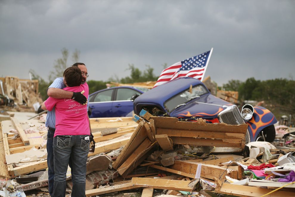 2014 年4 月29 日，一场龙卷风袭卷了美国阿肯色州的维洛尼亚（Vilonia），幸存者在断垣残壁之间拥抱。摄影：Mark Wilson, Getty