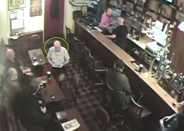 光头男(黄圈)与其他酒客在看其手上的平板电脑,当时酒杯(黄圈)仍完好无事。