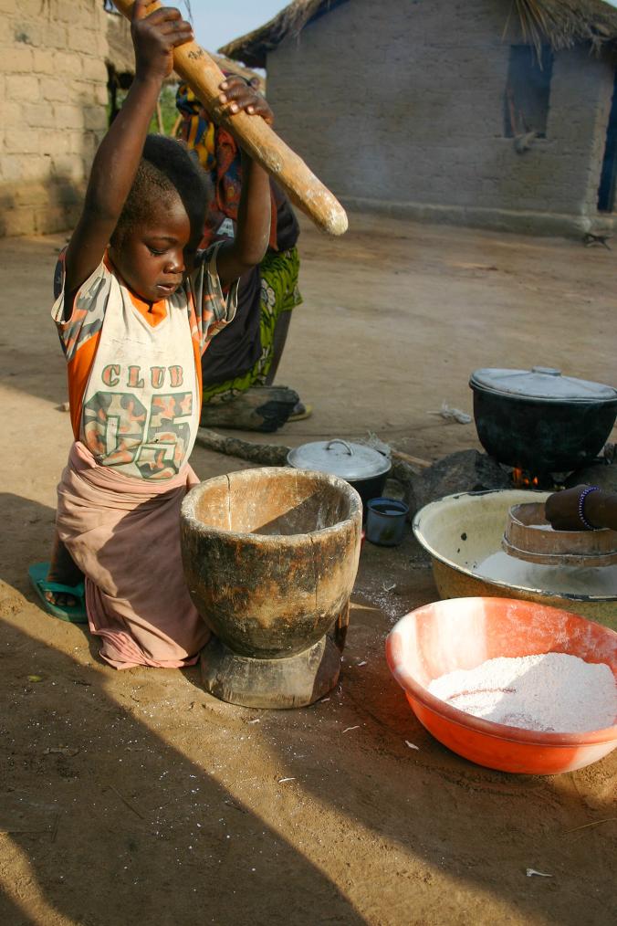 一个孩童在捣木薯,这是撒哈拉沙漠以南非洲的重要主食。照片摄于2012年。 PHOTOGRAPH BY ALBERT PODELL