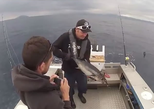 钓鱼男起初一脸自信抱起大鱼。