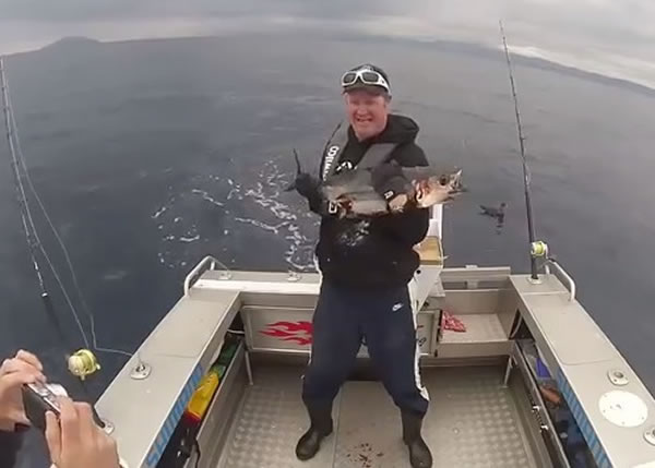 钓鱼男死撑之下,终于成功抱起吞拿鱼合照。