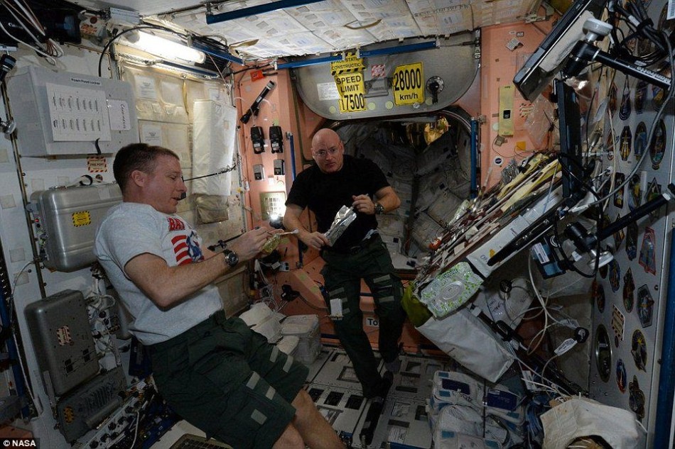 正在国际空间站上工作的宇航员特里-沃兹(左)和斯特科-凯利(右)。在这个轨道前哨,宇航员一直生活在微重力环境下。凯利将在空间站上逗留一年时间,帮助科学家了解长时